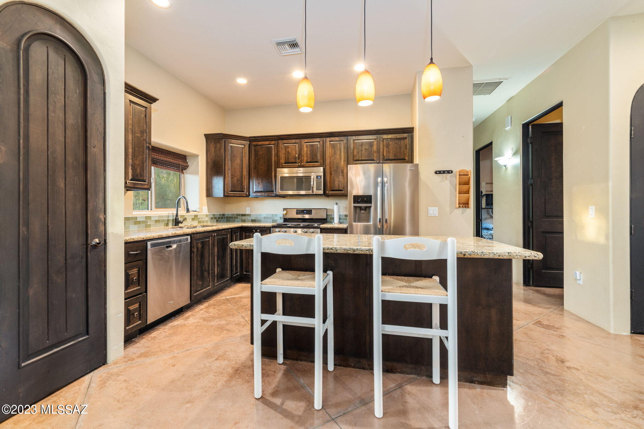 5670 Triangle X Place Tucson, AZ 85713 - Photo 23 of 36 a kitchen with stainless steel appliances kitchen island granite countertop a refrigerator and a stove top oven