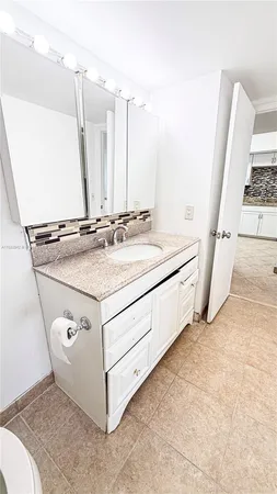 a view of utility room with sink and mirror