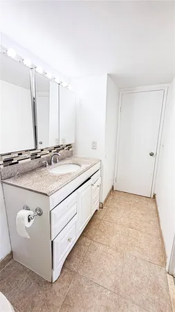 a spacious bathroom with a sink and a mirror
