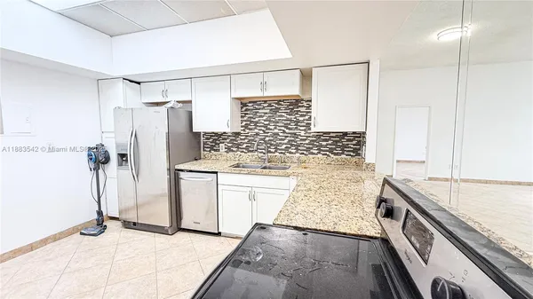 a bathroom with a granite countertop sink a toilet and shower