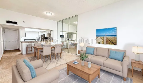 a living room with furniture and a view of kitchen