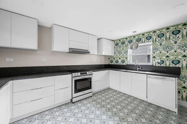 a kitchen with stainless steel appliances granite countertop a sink stove and cabinets