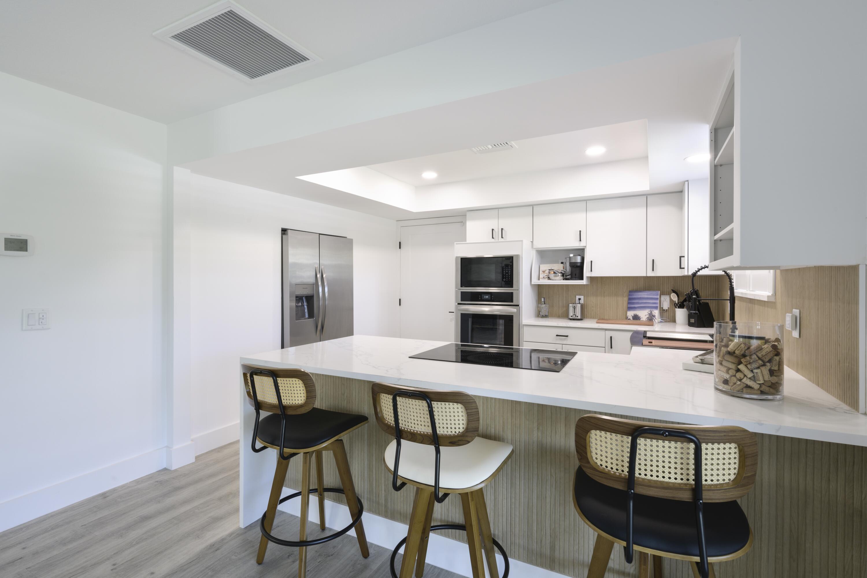 8585 Southeast Palm Street Hobe Sound, FL 33455 - Photo 13 of 43 a kitchen with stainless steel appliances a dining table chairs and wooden floor