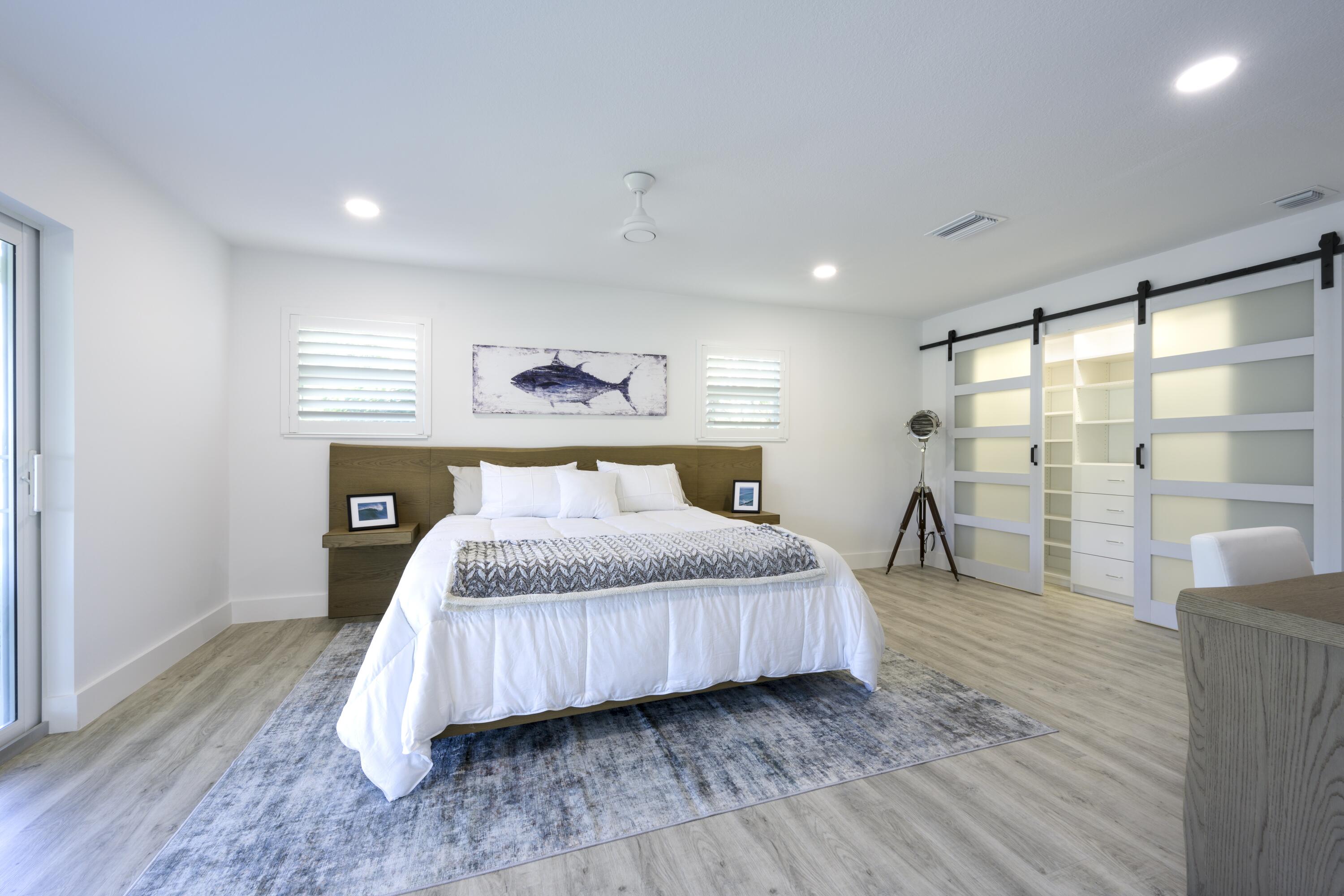 8585 Southeast Palm Street Hobe Sound, FL 33455 - Photo 16 of 43 a bedroom with a large bed and a large window