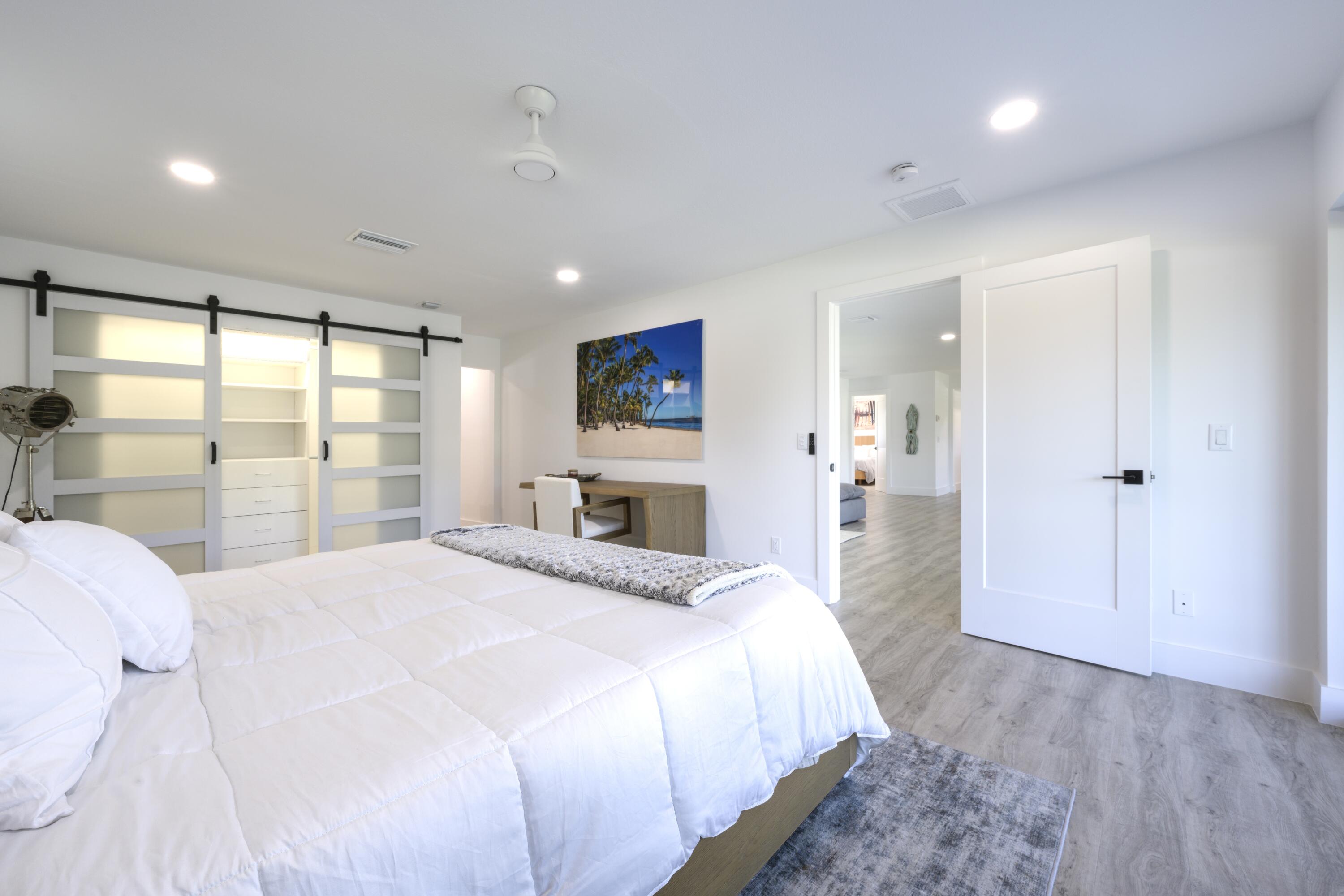 8585 Southeast Palm Street Hobe Sound, FL 33455 - Photo 17 of 43 a spacious bedroom with a large bed and a large window