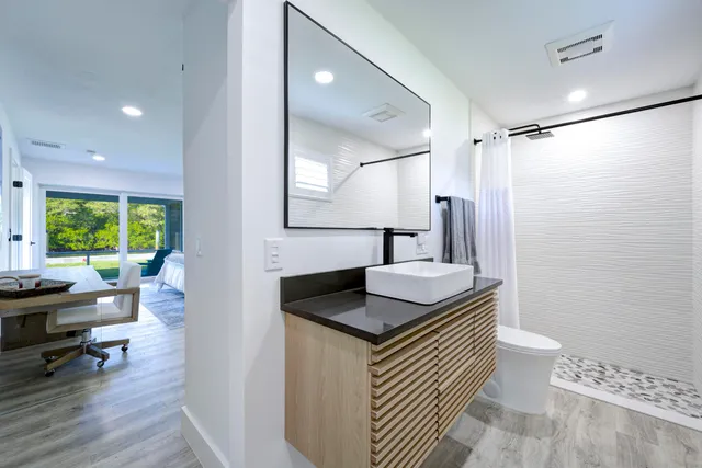 a bathroom with a granite countertop sink and a mirror