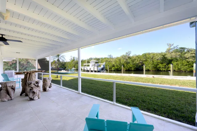 a view of a patio with table and chairs next to a yard