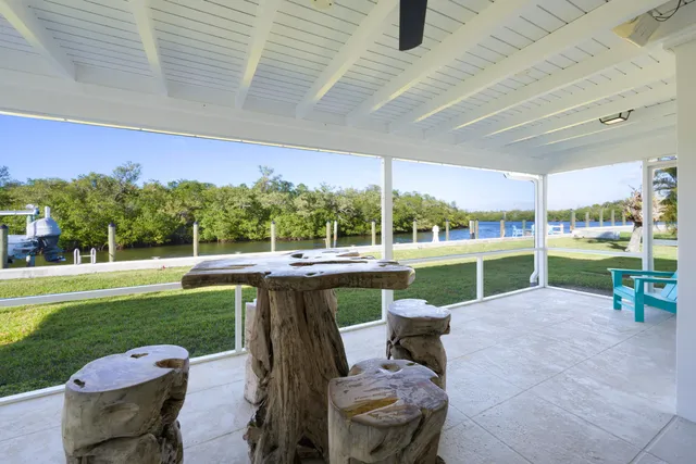 a view of a swimming pool and lounge chairs in back yard of a building