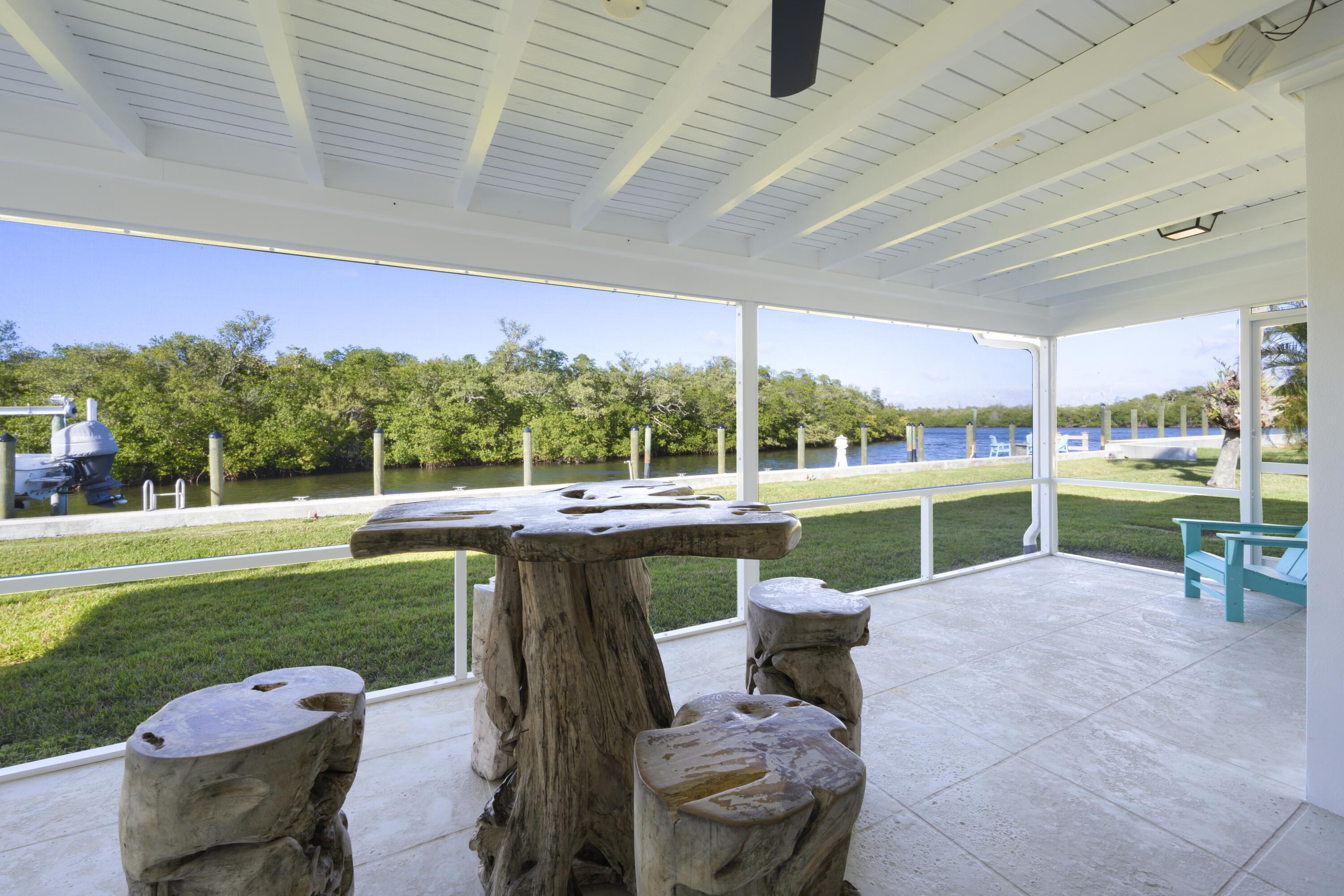 8585 Southeast Palm Street Hobe Sound, FL 33455 - Photo 28 of 43 a view of a swimming pool and lounge chairs in back yard of a building