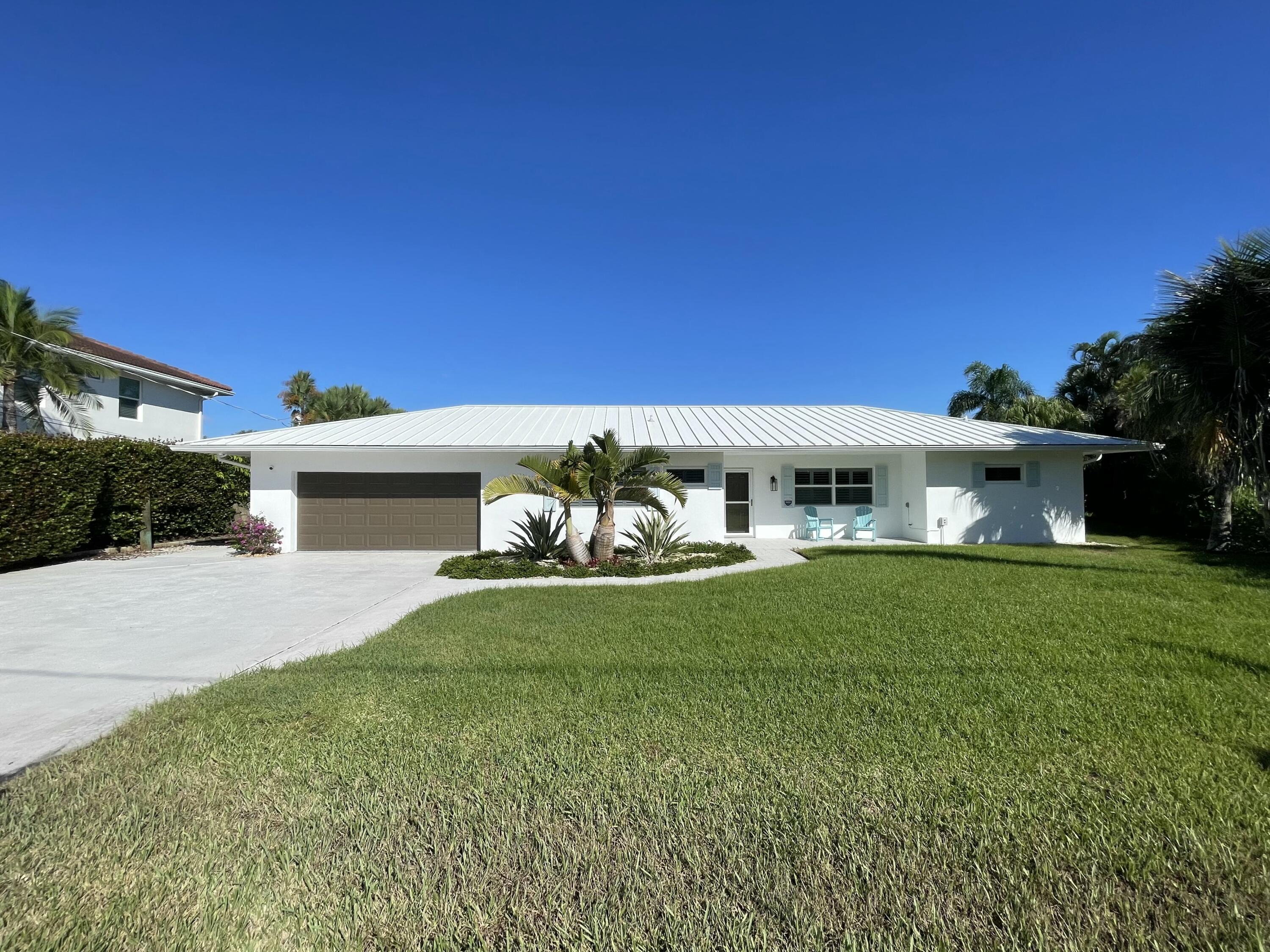 8585 Southeast Palm Street Hobe Sound, FL 33455 - Photo 4 of 43 a front view of a house with garden
