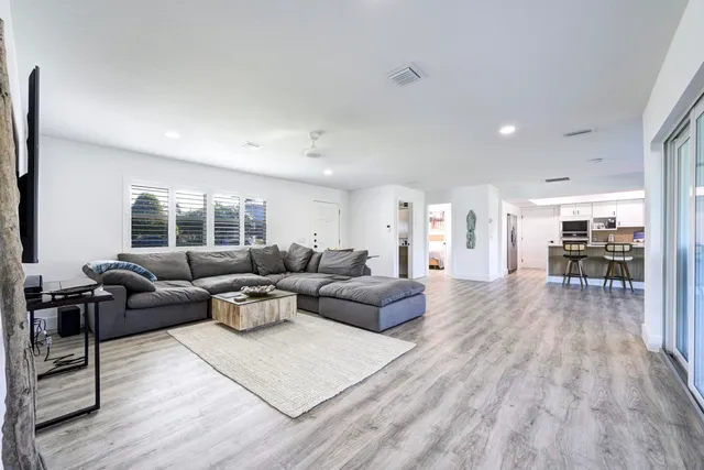 a living room with furniture and a wooden floor