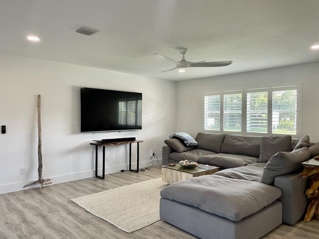8585 Southeast Palm Street Hobe Sound, FL 33455 - Photo 8 of 43 a living room with furniture and a flat screen tv