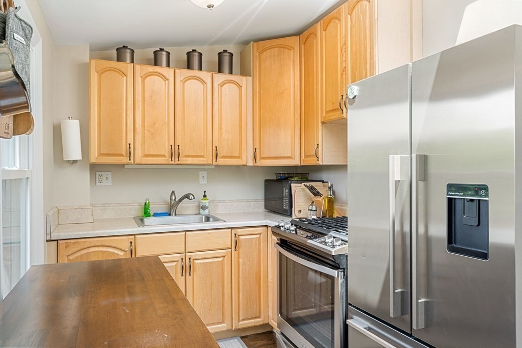 47 R Jamaica Street, Unit 3 Boston, MA 02130 - Photo 5 of 16 a kitchen with stainless steel appliances granite countertop a refrigerator a stove and a sink