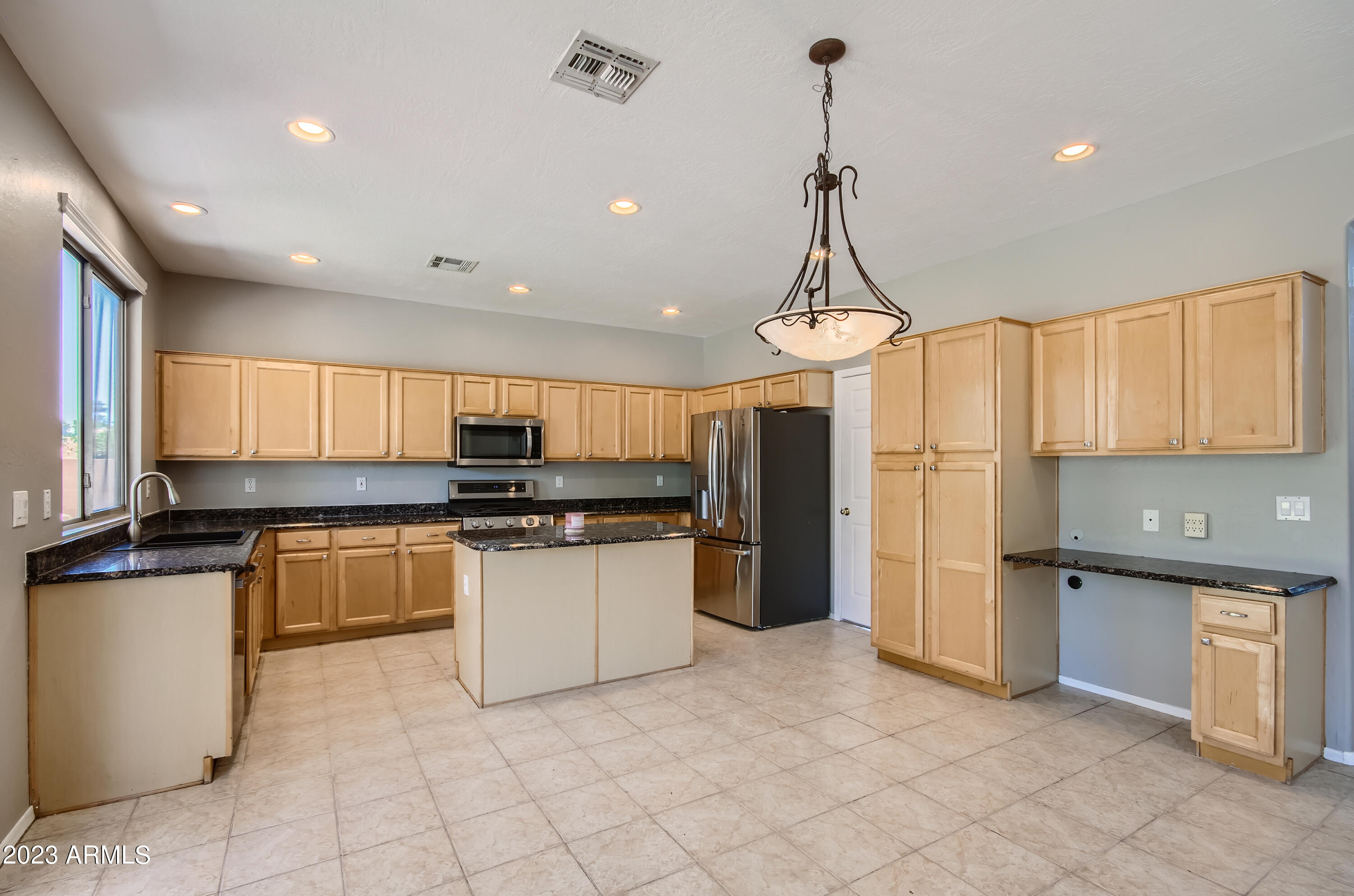 1885 East Smoke Tree Road Gilbert, AZ 85296 - Photo 2 of 3 a kitchen with stainless steel appliances granite countertop a refrigerator a stove a sink and a microwave