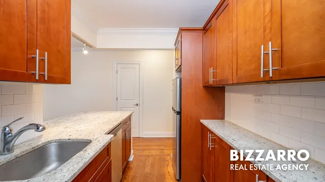 a kitchen with granite countertop a sink a stove and cabinets