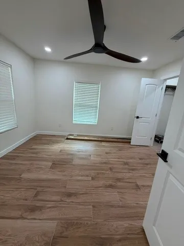 an empty room with wooden floor and window