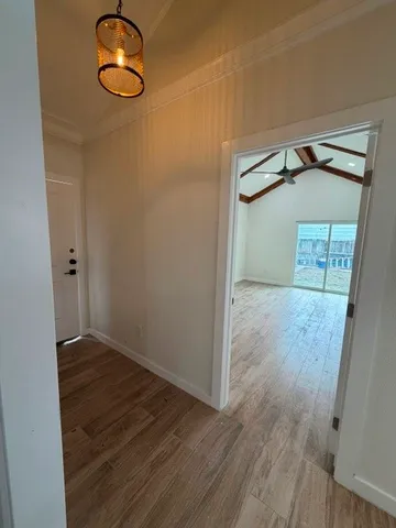 a view of empty room with wooden floor