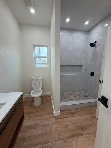 a bathroom with a sink a toilet and shower