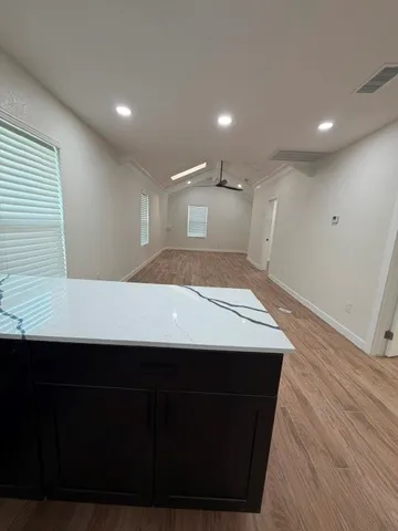 a kitchen with a sink a wooden floor and black cabinets