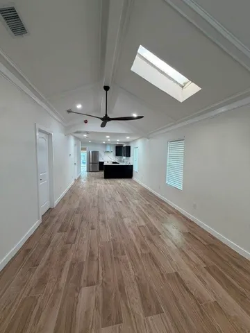 a view of empty room with wooden floor