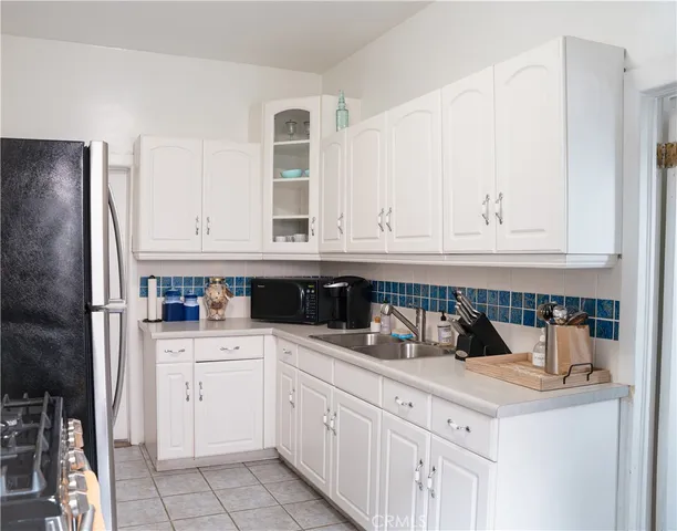 a kitchen with white cabinets and sink