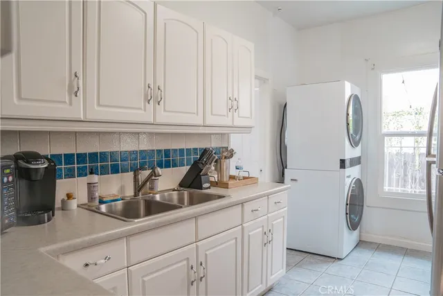 a kitchen with stainless steel appliances granite countertop a sink a refrigerator and a white cabinets