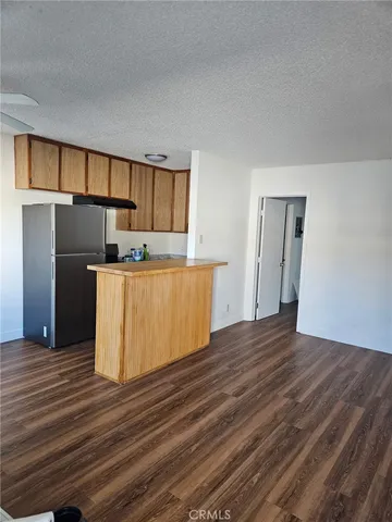 a kitchen with stainless steel appliances a refrigerator and wooden floor