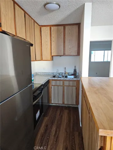 a kitchen with a sink a refrigerator and cabinets