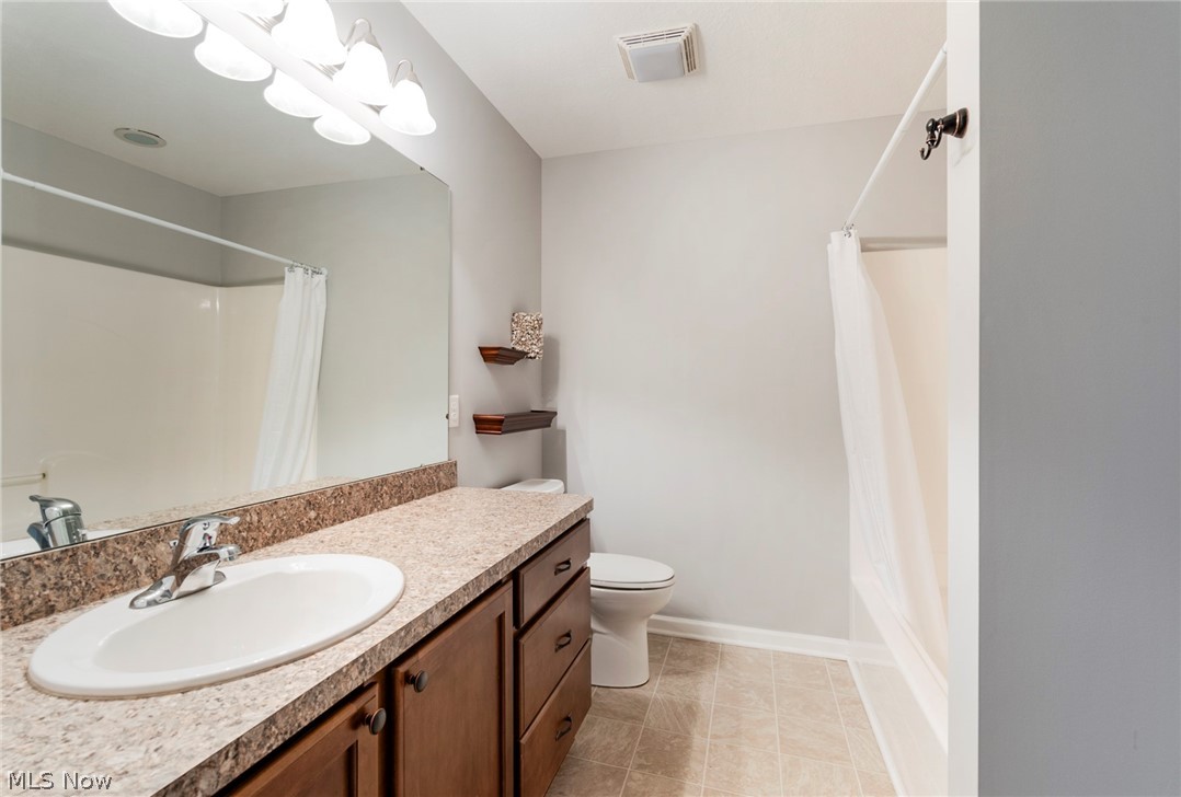 9151 Springfield Road, Unit 1902 Youngstown, OH 44514 - Photo 28 of 36 Full bathroom featuring vanity, toilet, tile floors, and shower / tub combo with curtain