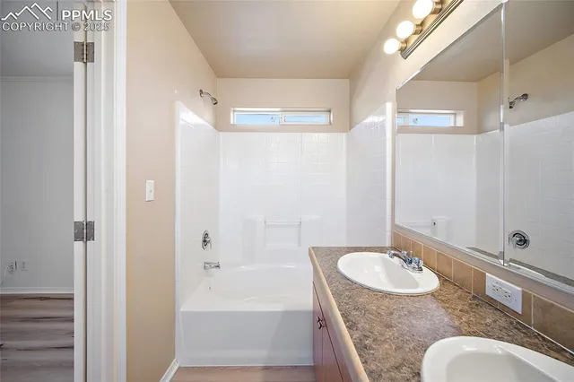 a bathroom with a sink double vanity granite tub shower and a mirror