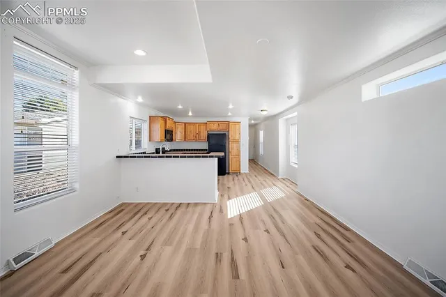 a view of a kitchen with wooden floor and a window