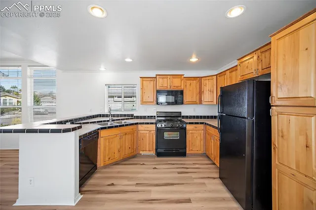 a kitchen with stainless steel appliances granite countertop refrigerator sink and stove