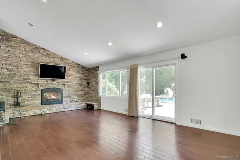 a view of a livingroom with a fireplace wooden floor and window