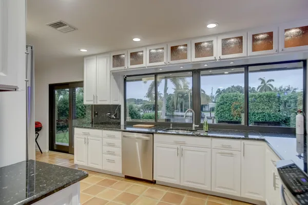 a large white kitchen with a sink and cabinets