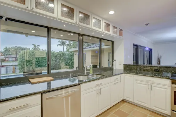 a kitchen with a sink and large windows