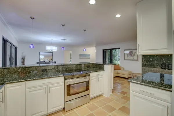 a kitchen with stainless steel appliances granite countertop a stove sink and cabinets