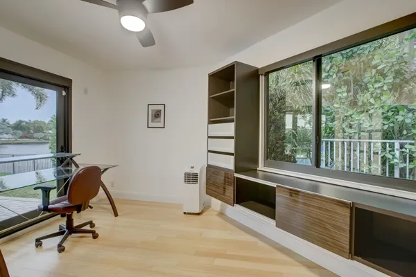 a view of a workspace with furniture and a window