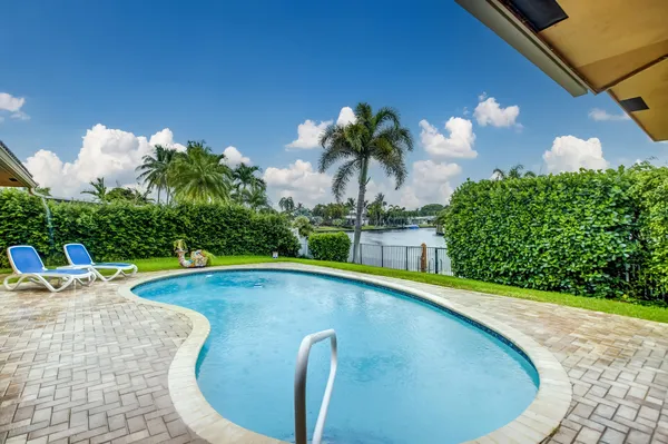 a view of a swimming pool with a yard and seating space