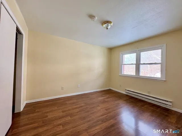 a view of a room with wooden floor and window