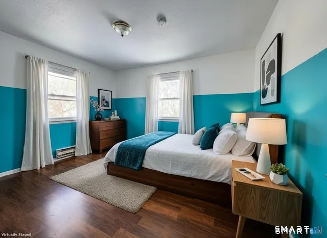 a bedroom with a bed wooden floor and window