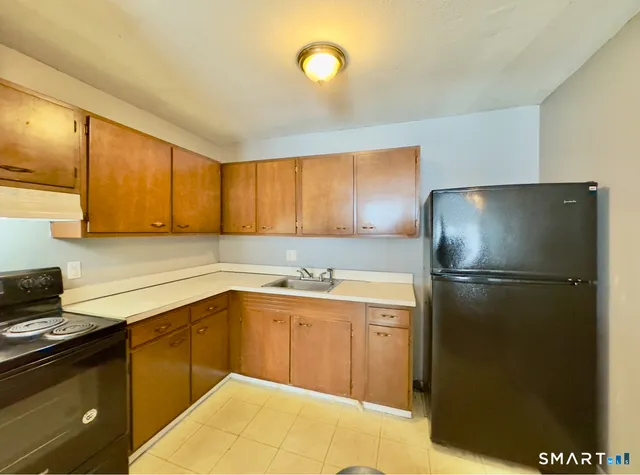 a kitchen with a sink a refrigerator and cabinets