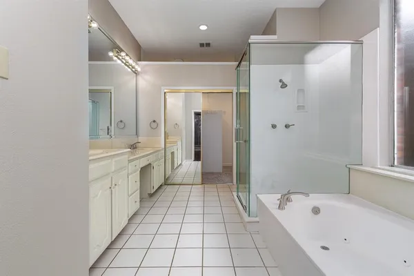 a bathroom with a tub a sink and a mirror