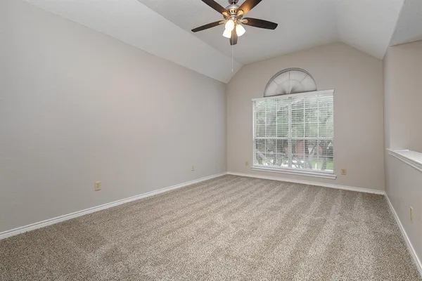 an empty room with windows and fan