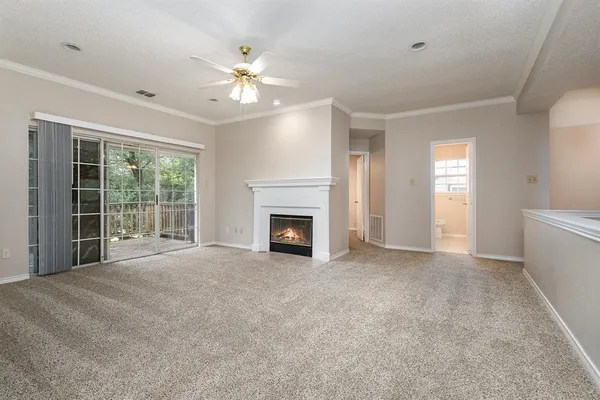 a view of an empty room with window and fire place