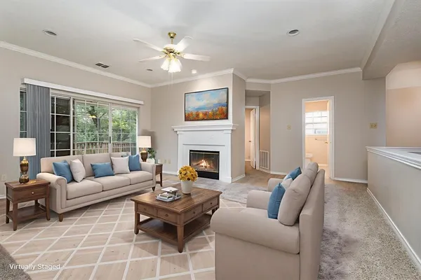 a living room with furniture a fireplace and a large window
