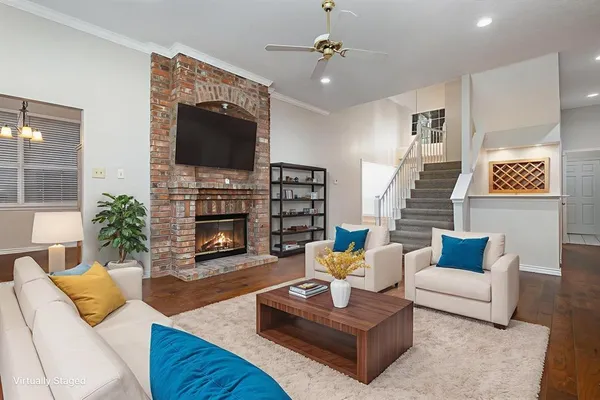 a living room with furniture a flat screen tv and a fireplace