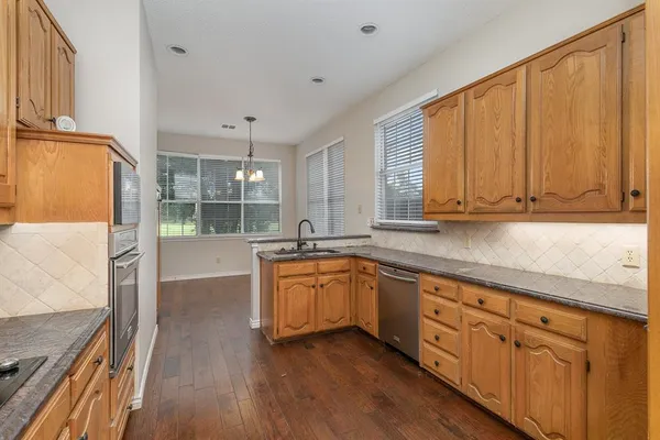 a kitchen with sink cabinets and wooden floor