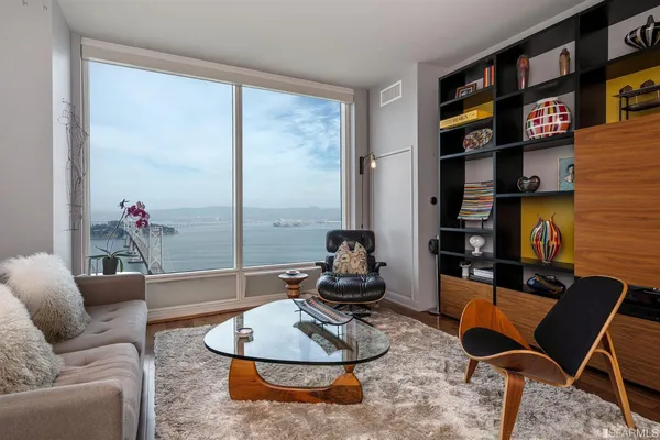 a living room with furniture a rug and a bookshelf