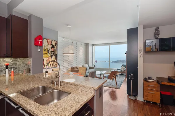 a kitchen with granite countertop a sink and a refrigerator