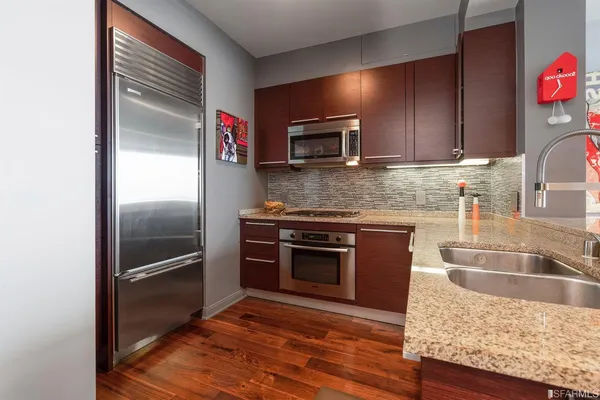 a kitchen with granite countertop stainless steel appliances and wooden cabinets